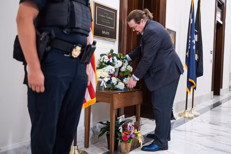 UNITED STATES - JULY 13: A representative from the Kurdistan Communities Assembly lays flowers outside the office of the late Sen. Lindsey Graham, R-S.C., in Russell building on Monday, July 13, 2026. Graham, who sponsored the Save the Kurds Act, passed away on July 11th. (Tom Williams/CQ-Roll Call, Inc via Getty Images)