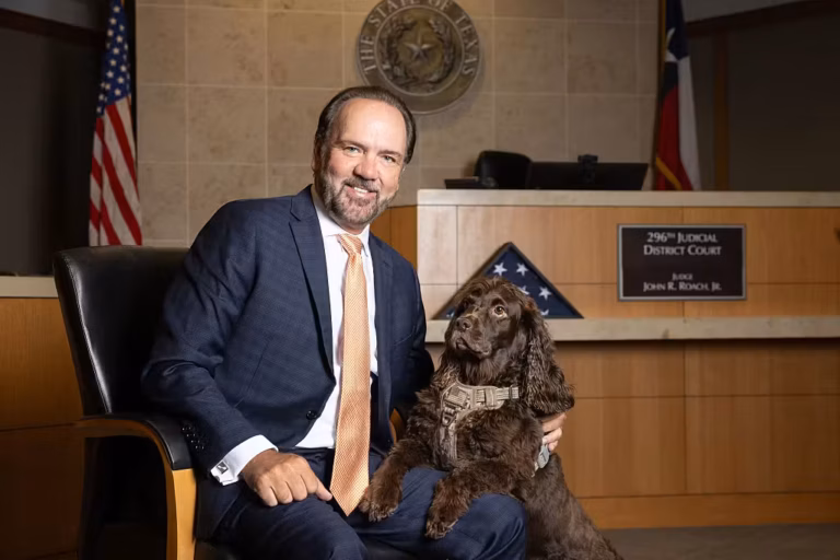 udge John Roach Jr., the presiding judge of the 296th District Court, poses for a photo with his Boykin Spaniel named Justice in his courtroom in the Collin County Courthouse in McKinney, TX, Friday, June 12, 2026.