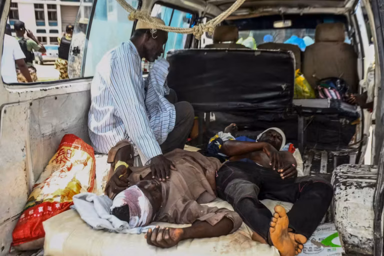 Injured men lay in a van as they arrive for treatment after a wave of suicide attacks in the North East of Nigeria, in Maiduguri on June 29, 2024. At least 18 people were killed and 19 seriously wounded in suicide attacks targeting a wedding, a hospital and a funeral in northeastern Nigeria on June 29, authorities said. The region has been scarred by more than a decade of violence by jihadist group Boko Haram, which did not immediately claim responsibility for the string of attacks. (Photo by Audu MARTE / AFP)